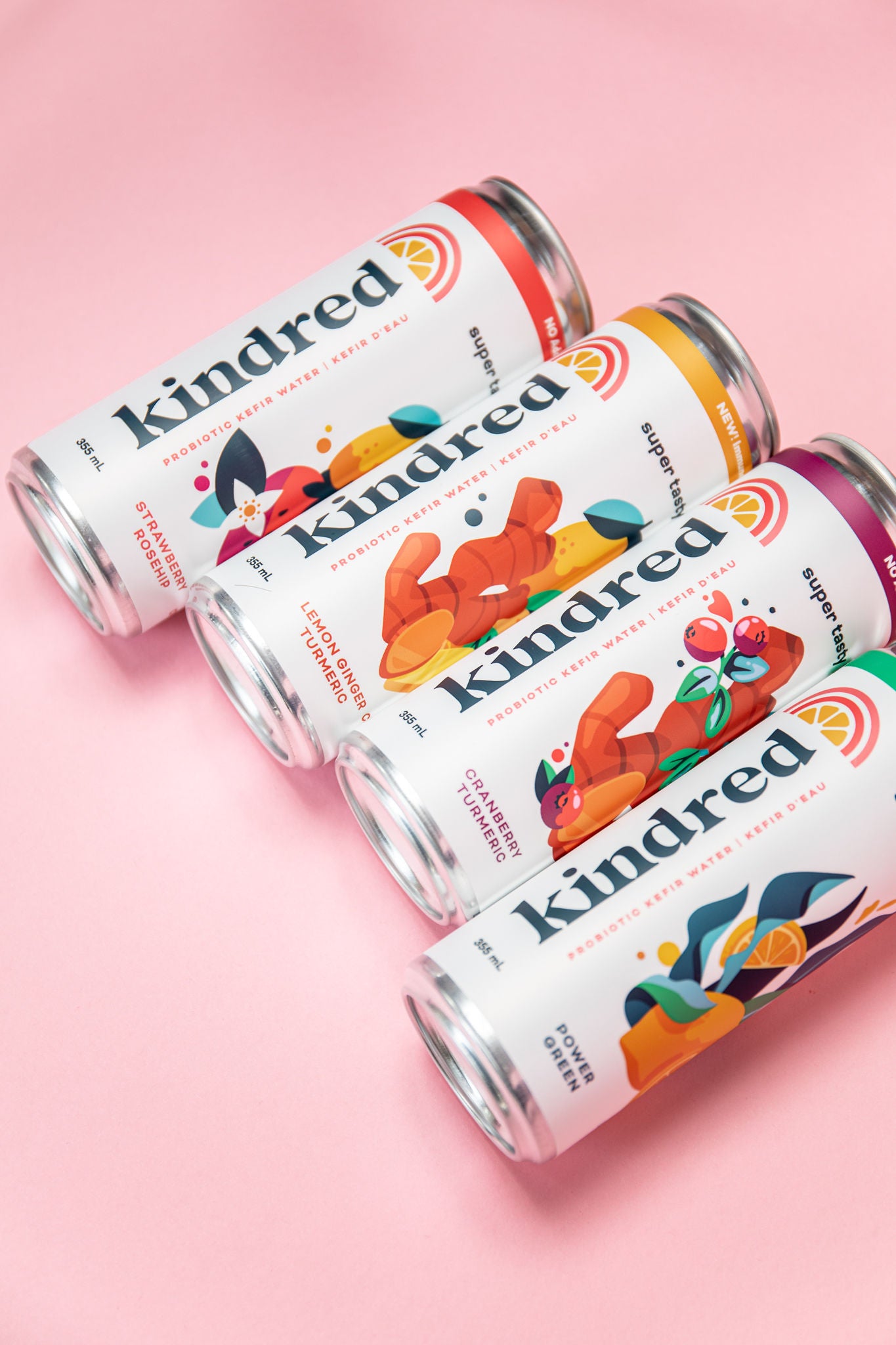 Kefir Water Cans in 4 flavours from left to right - Strawberry Rosehip, Lemon Ginger Turmeric, Cranberry Turmeric, Power Green